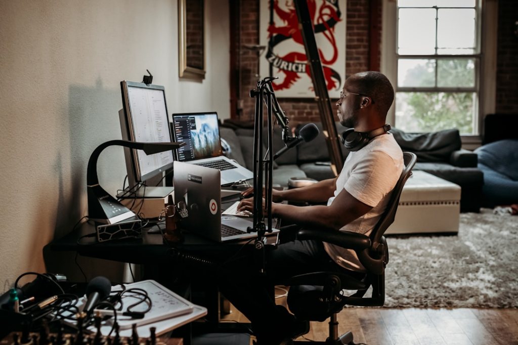 man in white t-shirt sitting on black office rolling chair by Kit (formerly ConvertKit)